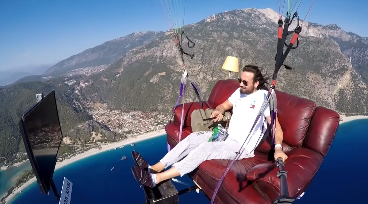 Paragliding and Chill! Turkish Paraglider Hasan Kaval Soars in Sky on Couch and Watches Tom & Jerry on TV! Crazy Video Goes Viral