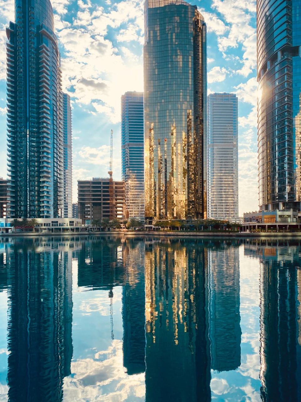 modern city district with skyscrapers reflecting in pond